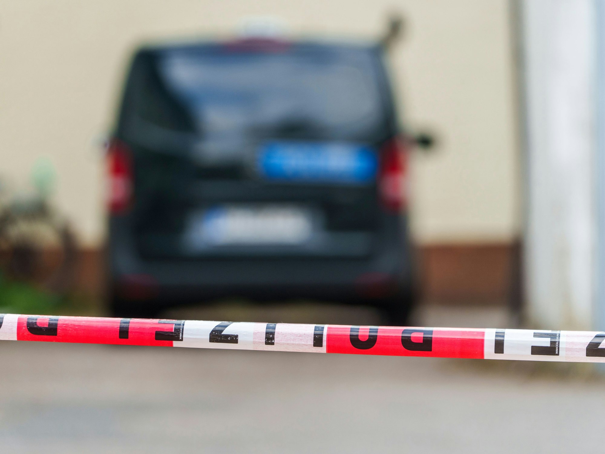 Ein Polizeifahrzeug steht hinter Absperrband.