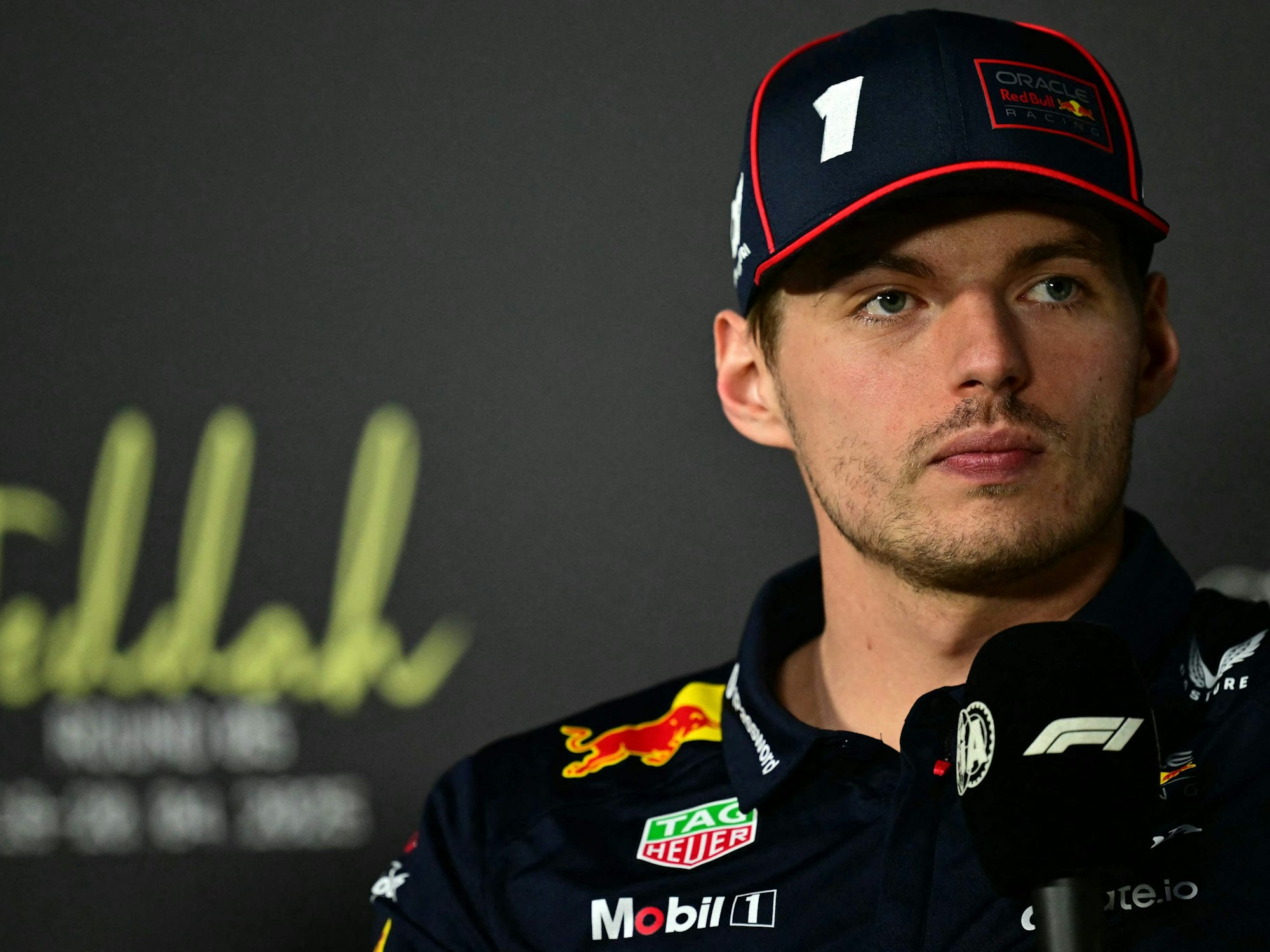Max Verstappen hält ein Mikrofon in der Hand.