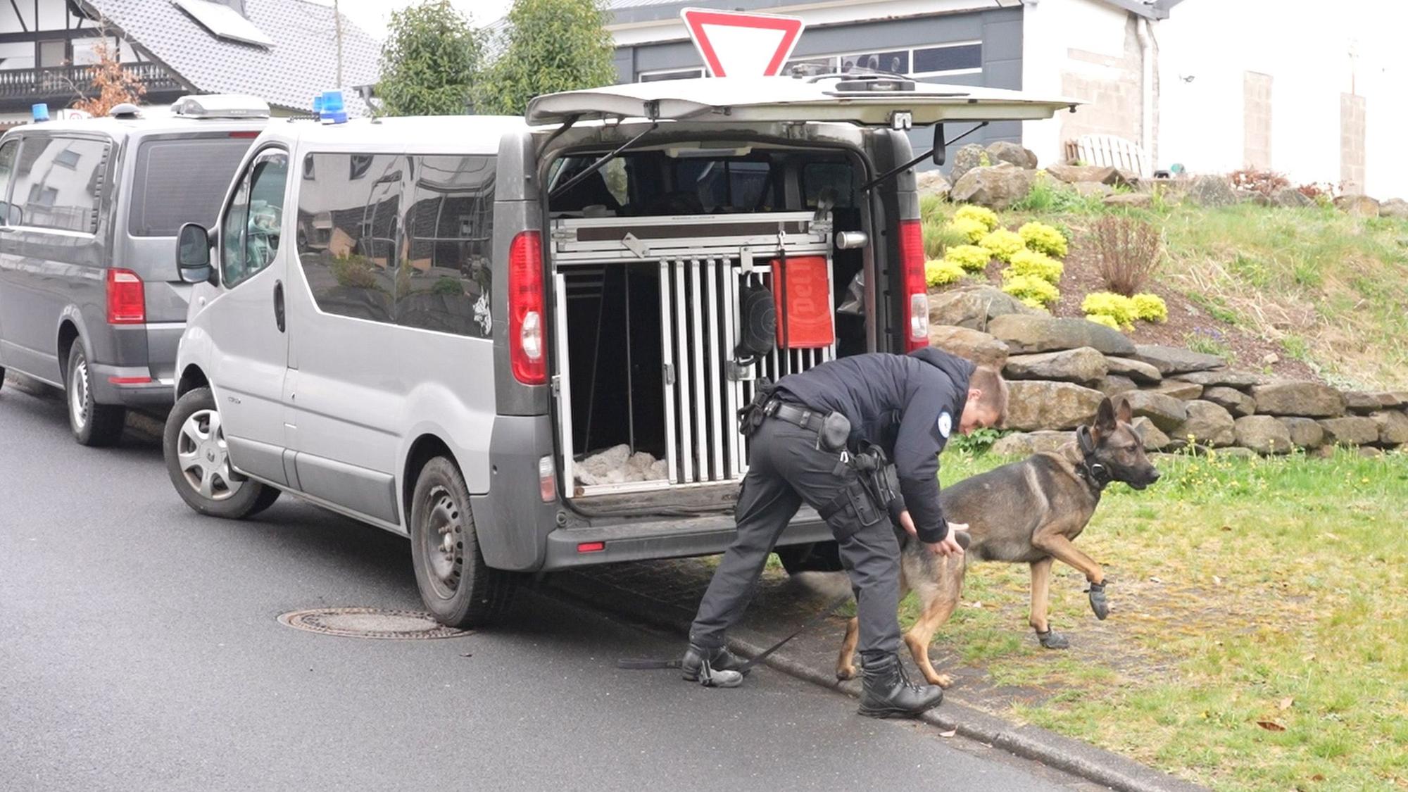 Ein Polizist und ein Suchhund bereiten sich auf einen Einsatz vor.