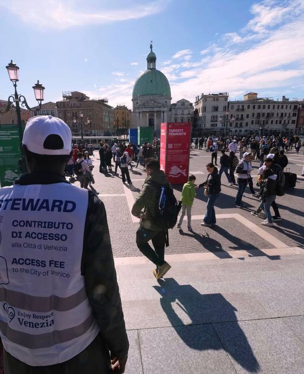 Kontrolleure überprüfen die QR-Codes von Touristen und Touristinnen vor dem Hauptbahnhof in Venedig. Für einen Besuch in Venedig muss jetzt wieder Eintritt bezahlt werden.