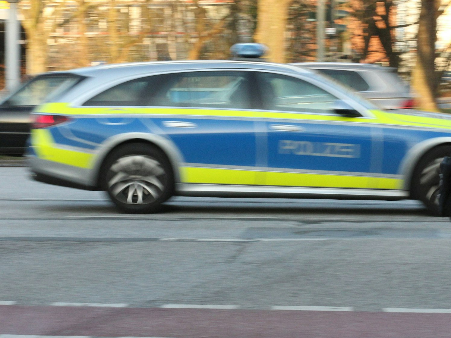 Ein Einsatzwagen der Polizei rast die Saarlandstraße entlang.