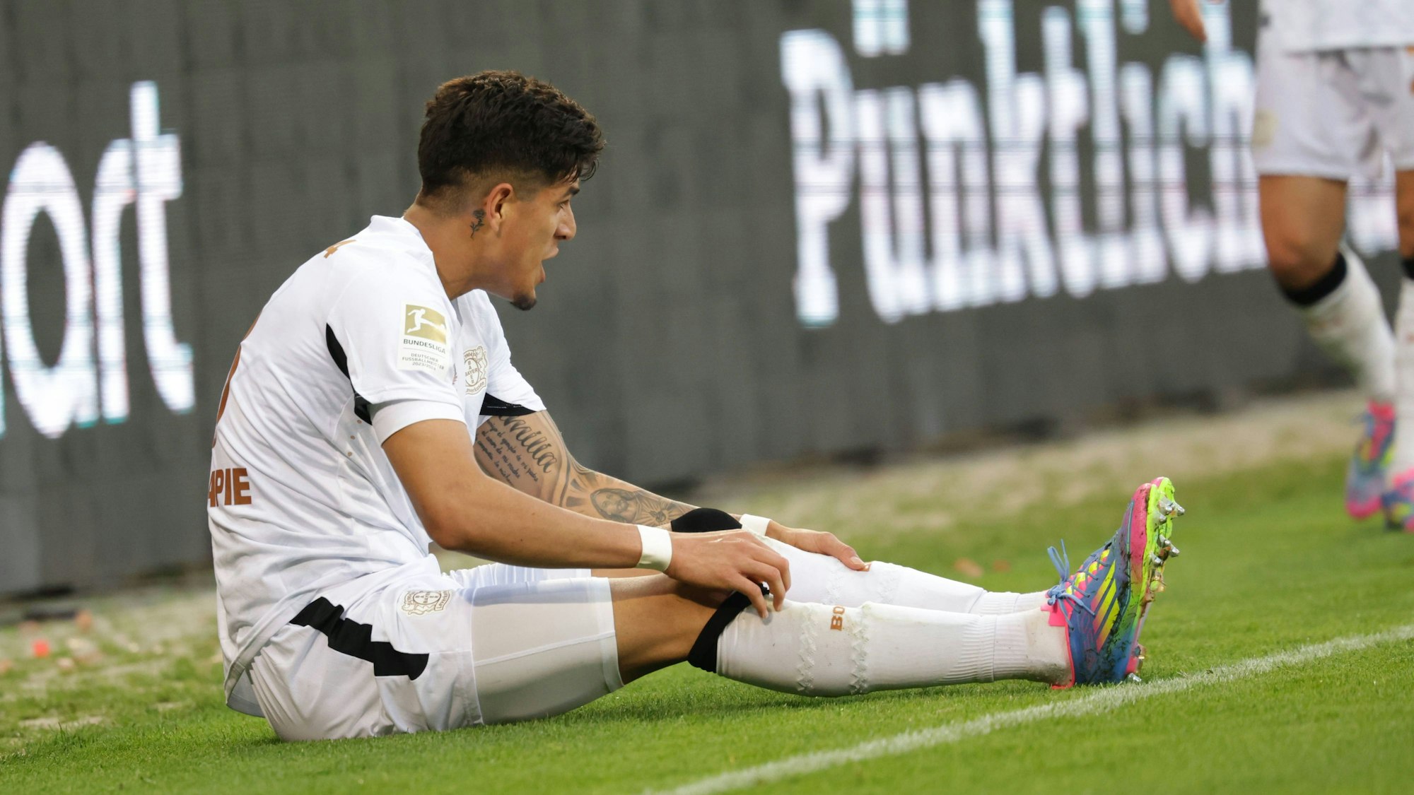 Piero Hincapie sitzt auf dem Spielfeld.