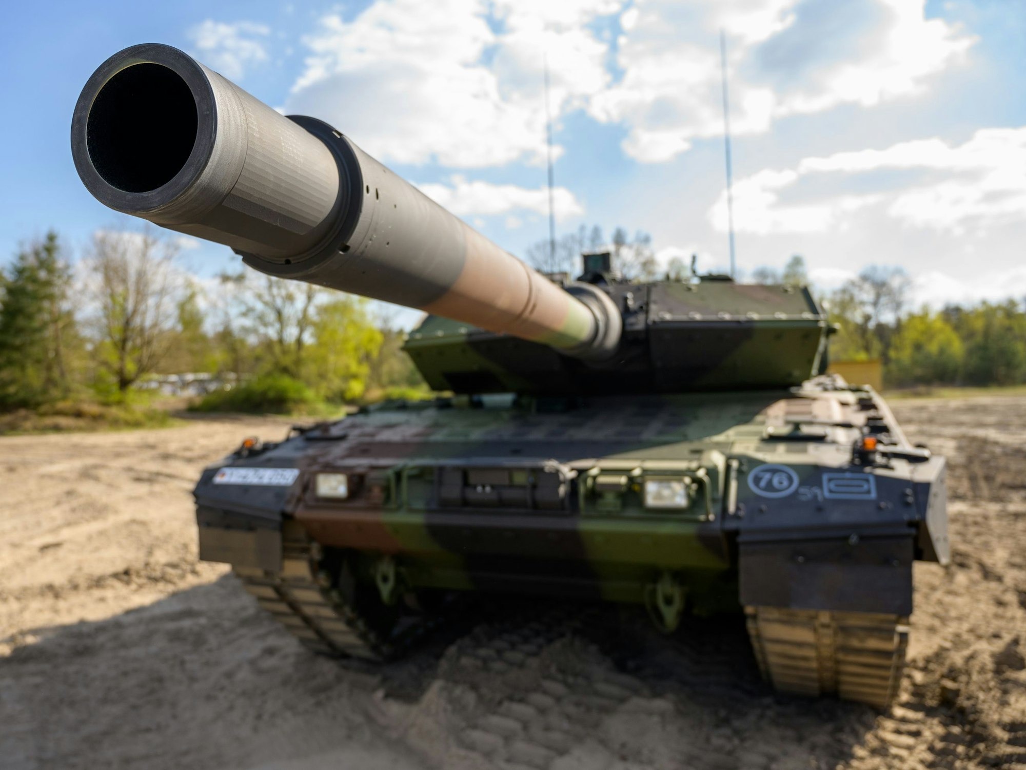 Ein Kampfpanzer steht auf einem Übungsplatz.
