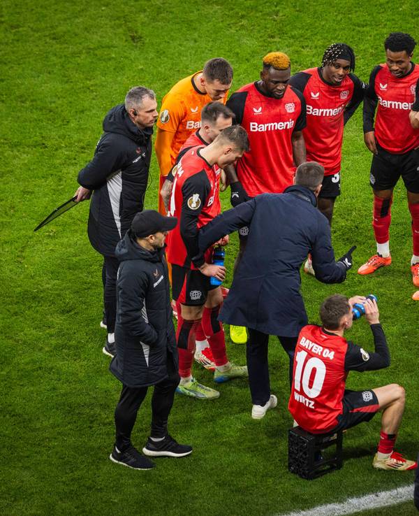 Die Mannschaft von Bayer Leverkusen bildet auf dem Rasen einen Kreis.