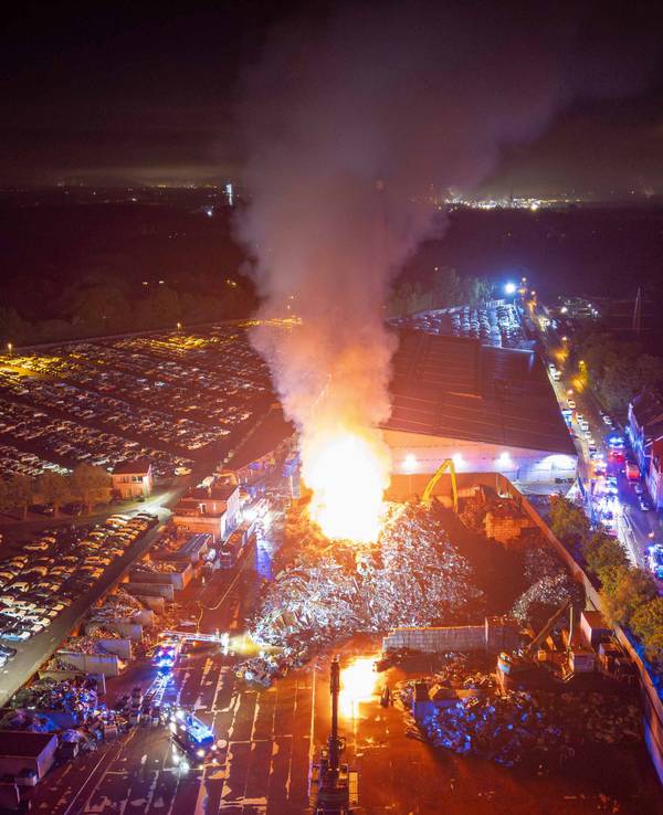 Flammen und Rauch steigen in den nächtlichen Himmel über dem Essener Stadtteil Altenessen. Ein Schrottberg mit einer Fläche von rund 10.000 Quadratmetern und 15 Metern Höhe sei in Brand geraten, sagte ein Sprecher der Feuerwehr am frühen Morgen.