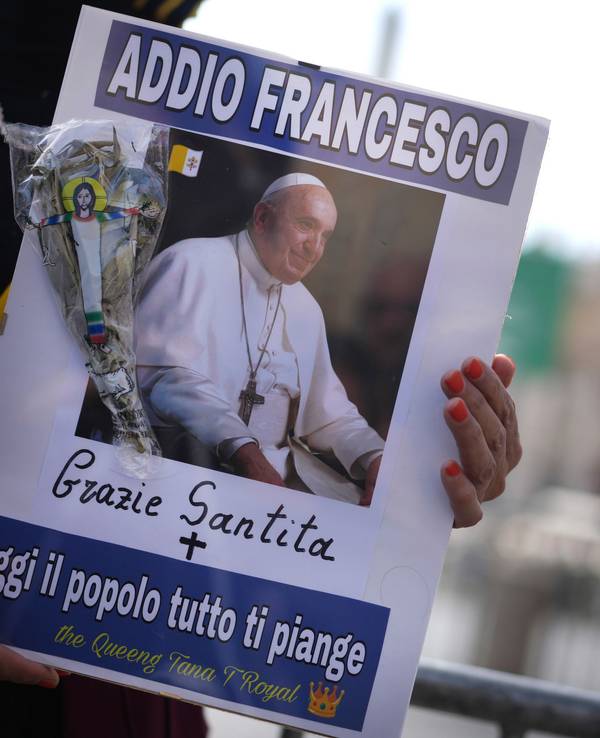 Eine Frau hält ein Bild von Papst Franziskus, auf dem in italienischer Sprache zu lesen ist: "Lebe wohl, Franziskus, danke, Seine Heiligkeit, heute weint das ganze Volk um dich".