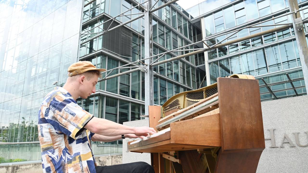 Thelonious Herrmann alias „Stadtgeklimper“ am Piano vor dem Neven DuMont Haus in Köln.