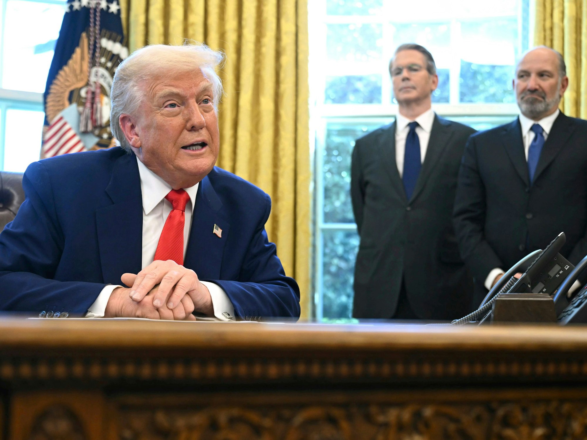 US-Präsident Donald Trump im Oval Office des Weißen Hauses, dahinter Finanzminister Scott Bessent (Mitte) und Handelsminister Howard Lutnick.