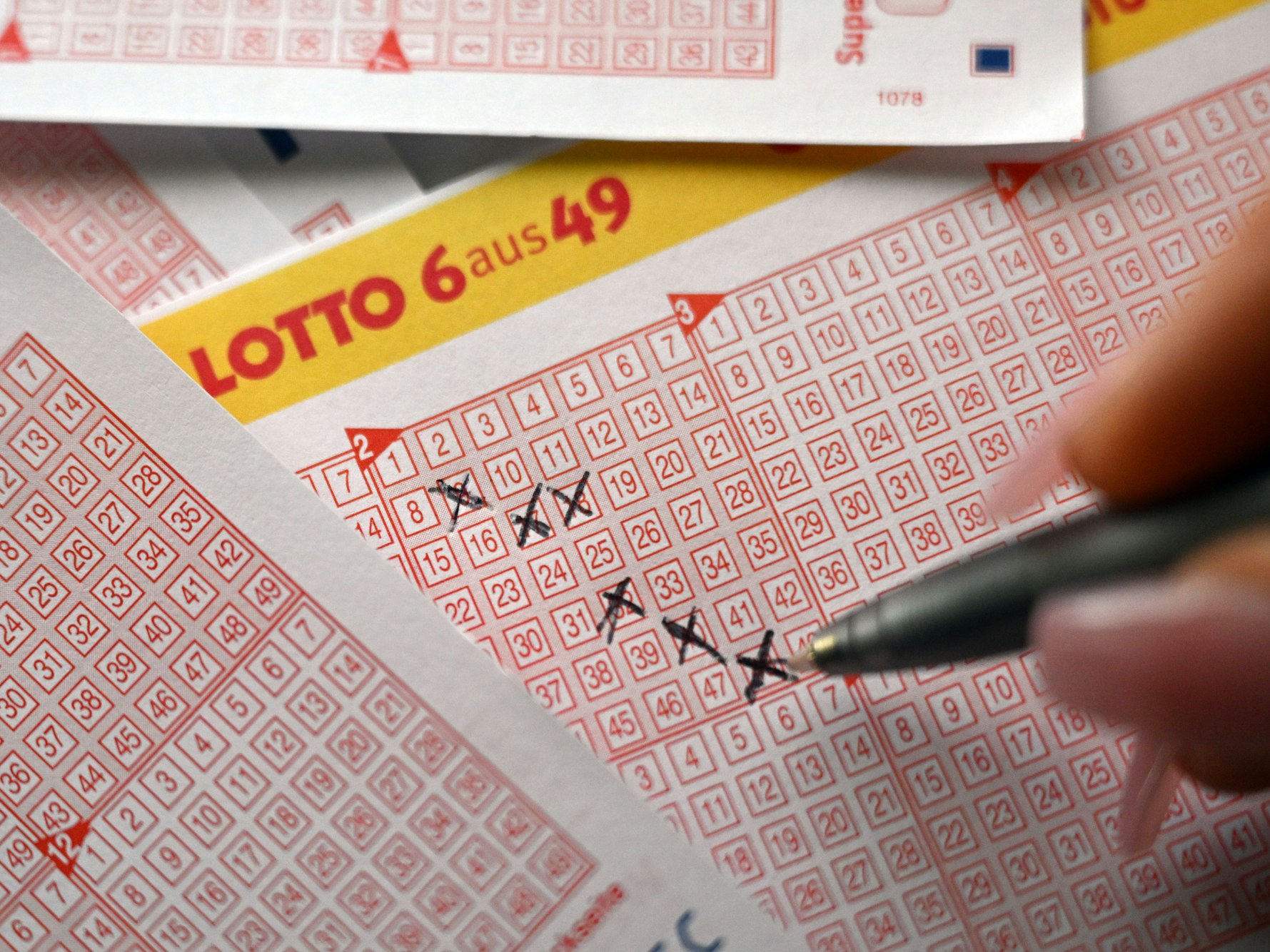 Eine Person füllt einen Lottoschein aus.