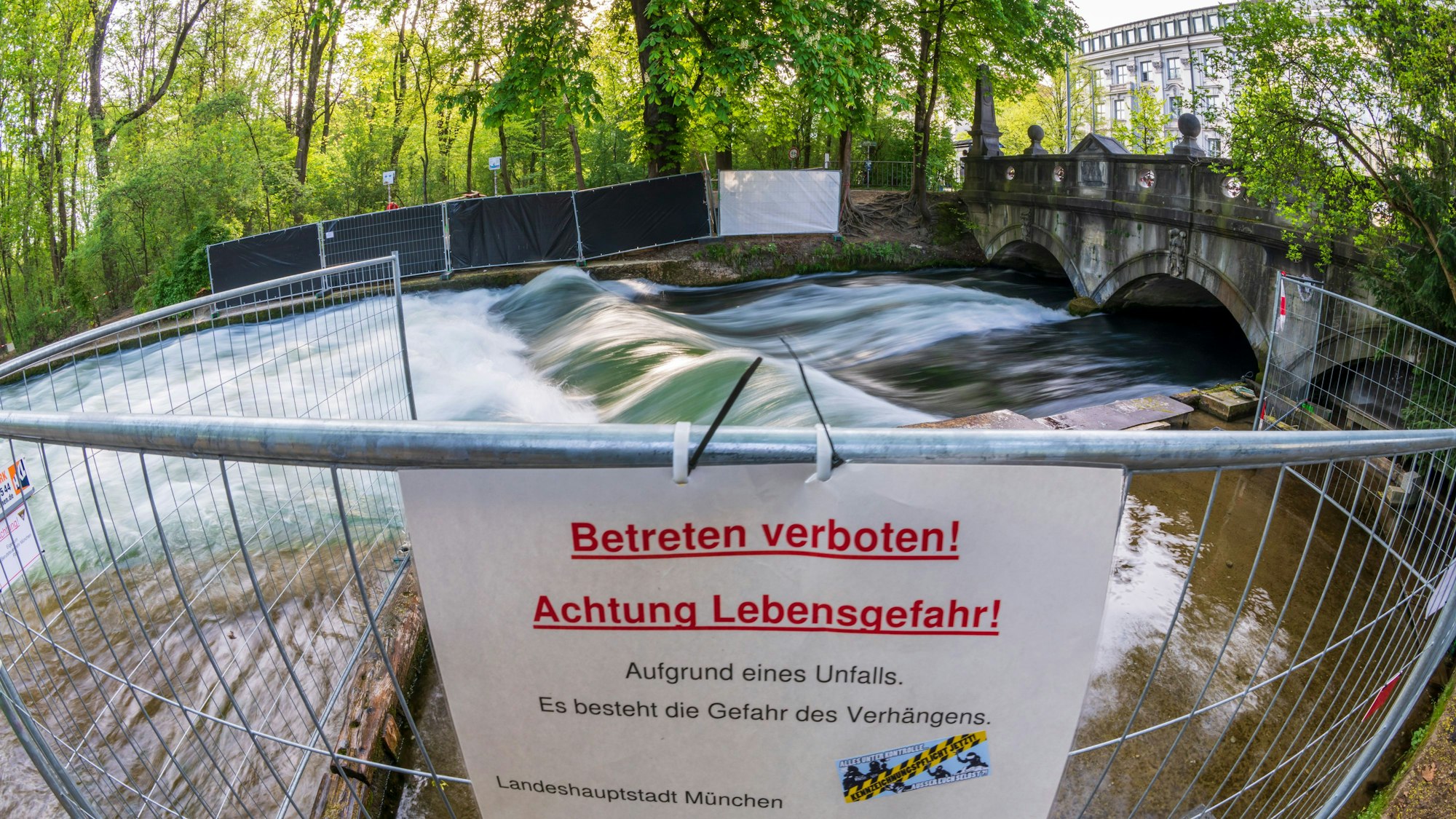 Ein Schild mit der Aufschrift „Betreten verboten! Achtung Lebensgefahr!“ hängt am 23. April 2025 an einer Absperrung. Die Eisbachwelle im Englischen Garten in München ist nach einem Surf-Unfall weiterhin gesperrt.