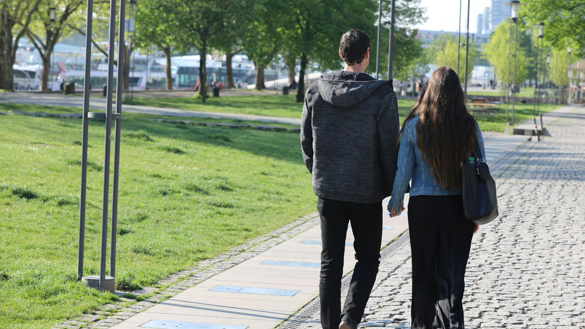 Ein Paar schlendert am 26. April 2025 den Rhein in Köln entlang.