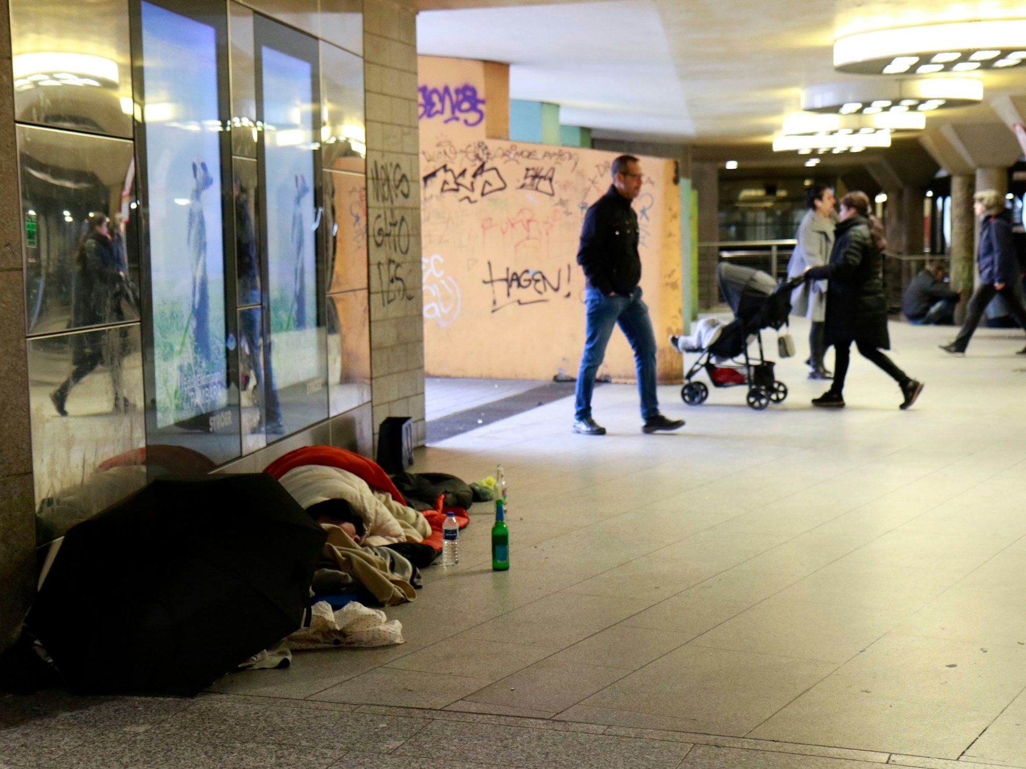 Personen liegen auf dem Boden, während andere Personen an ihnen vorbei laufen.