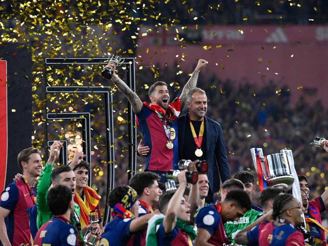Hansi Flick (rechts) und Barcelonas Inigo Martinez Berridi bejubeln im Kreise ihrer Mannschaft den Sieg im spanischen Pokal-Finale.
