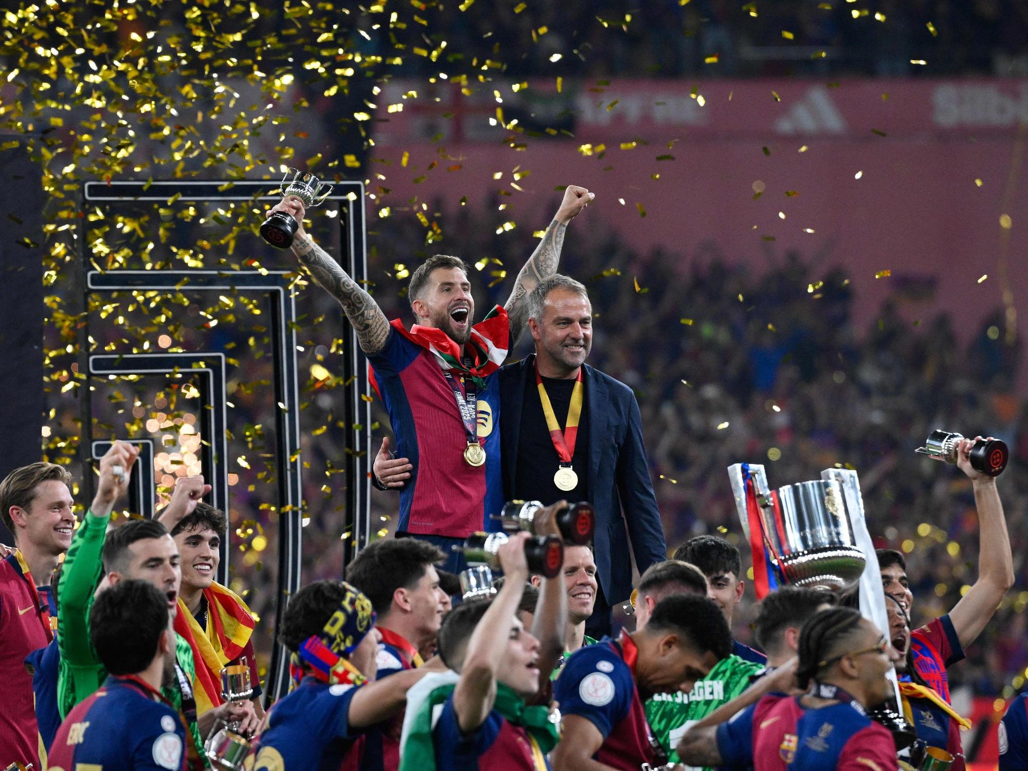 Hansi Flick (rechts) und Barcelonas Inigo Martinez Berridi bejubeln im Kreise ihrer Mannschaft den Sieg im spanischen Pokal-Finale.