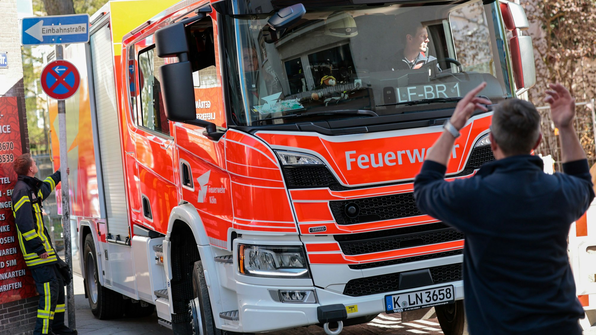 Ein Einsatzfahrzeug der Feuerwehr wird im April 2025 von einem Feuerwehrmann in einer engen Straße eingewiesen.