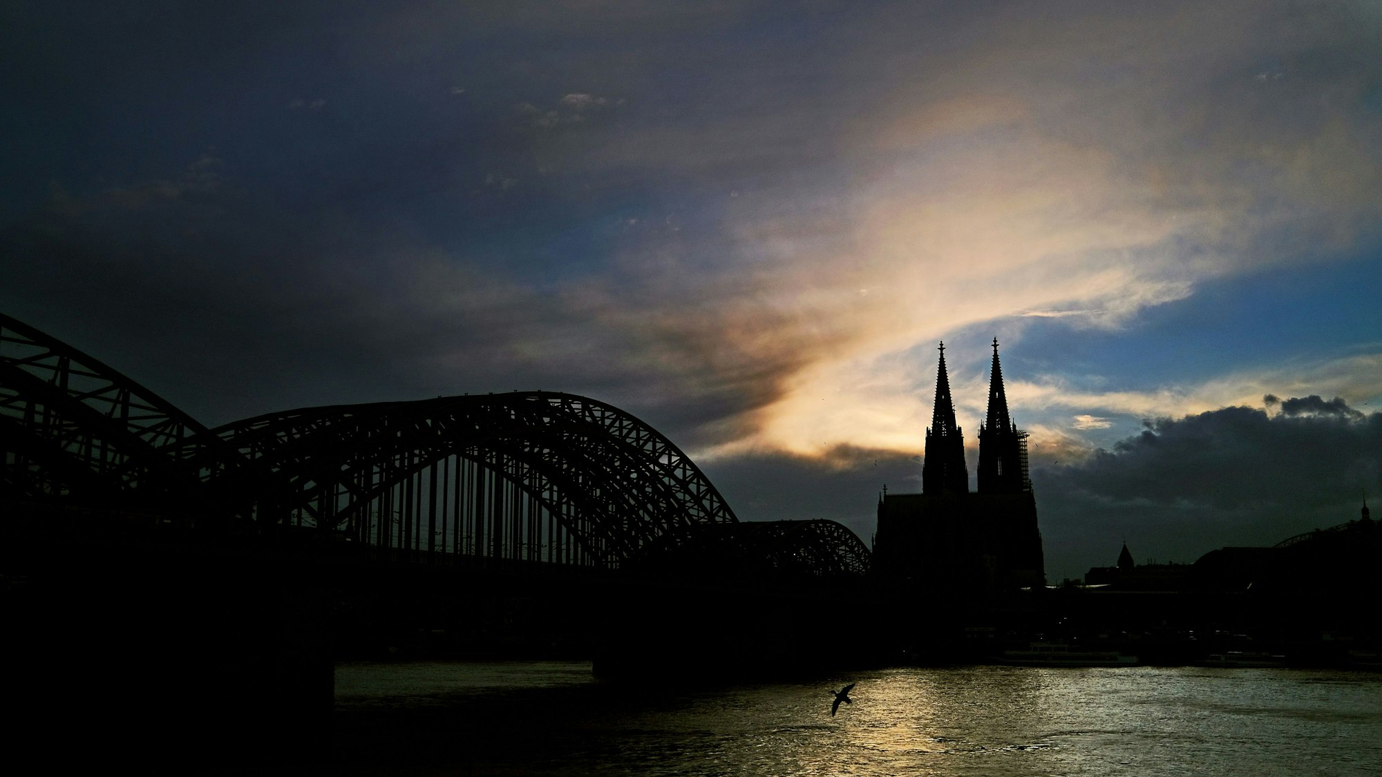 Hinter dem Dom ziehen Wolken an der untergehenden Sonne vorbei. Nach dem Mega-Blackout in Spanien und Portugal gibt die Bundesnetzagentur Entwarnung für Deutschland.