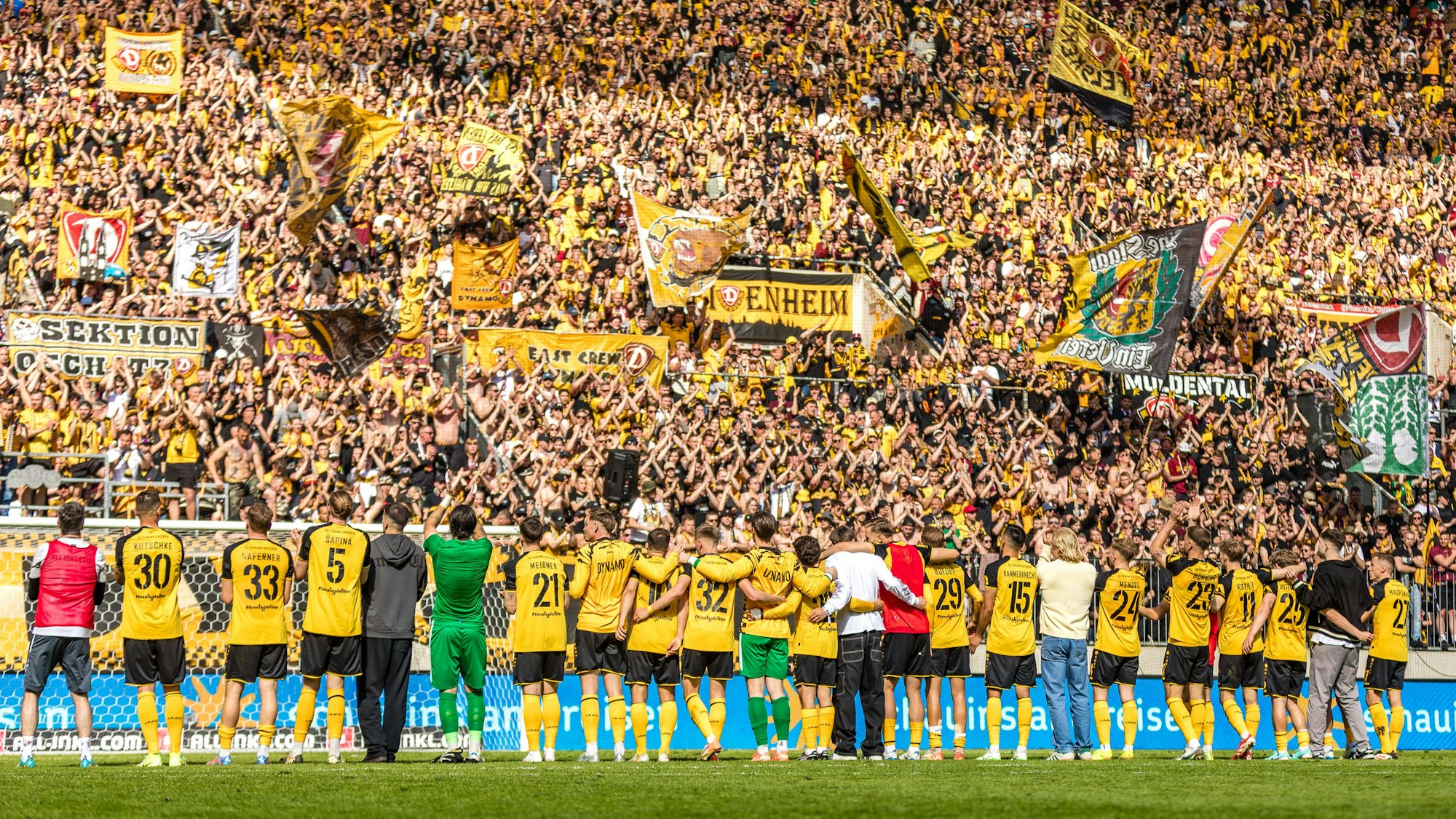 Die Spieler von Dynamo Dresden feiern mit den Fans.