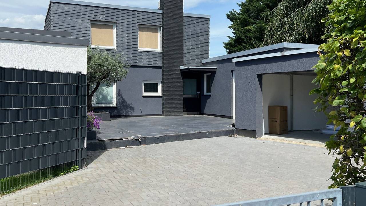 Die Fenster einer Villa im ersten Stock sind verhängt.