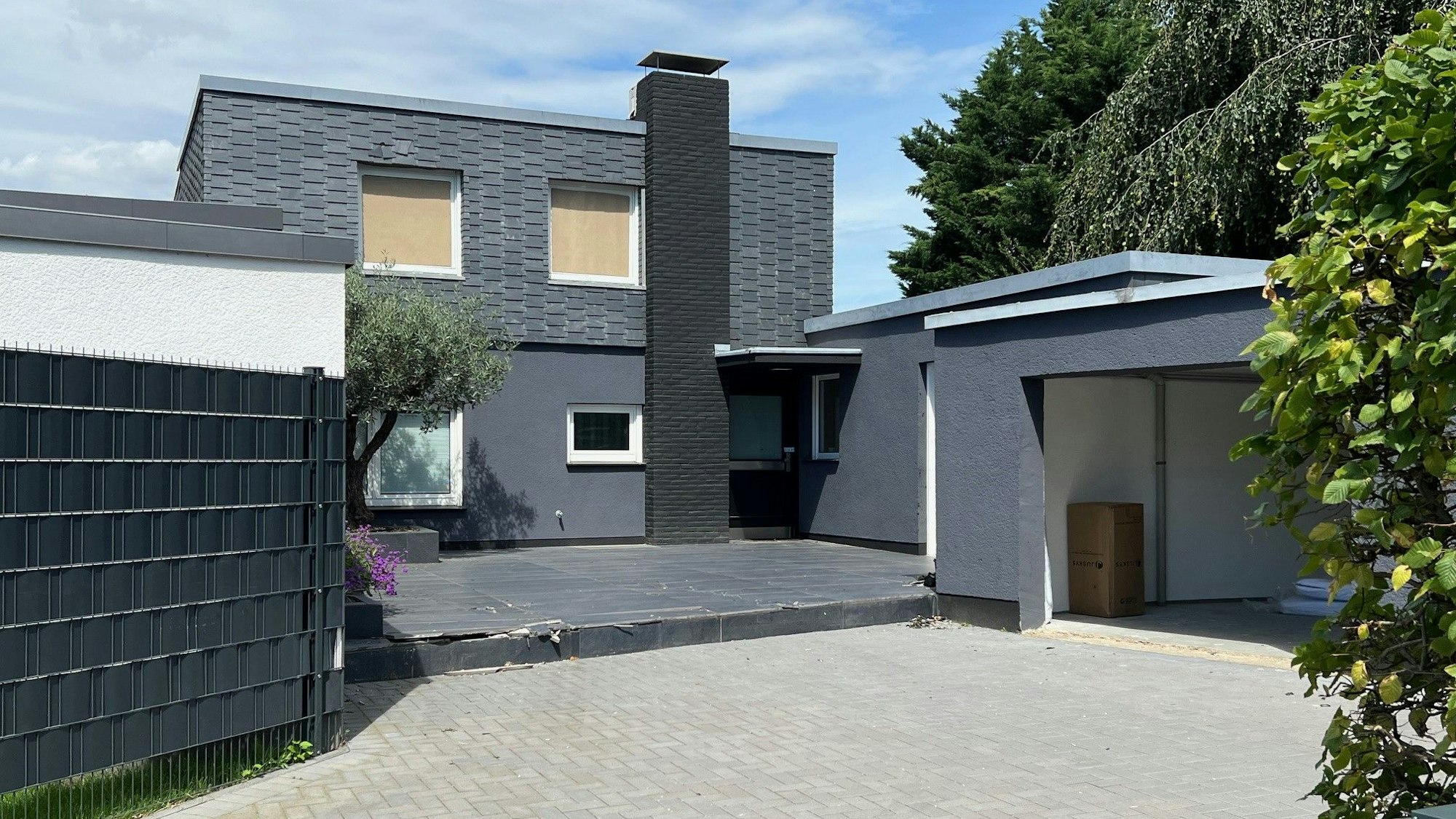 Die Fenster einer Villa im ersten Stock sind verhängt.