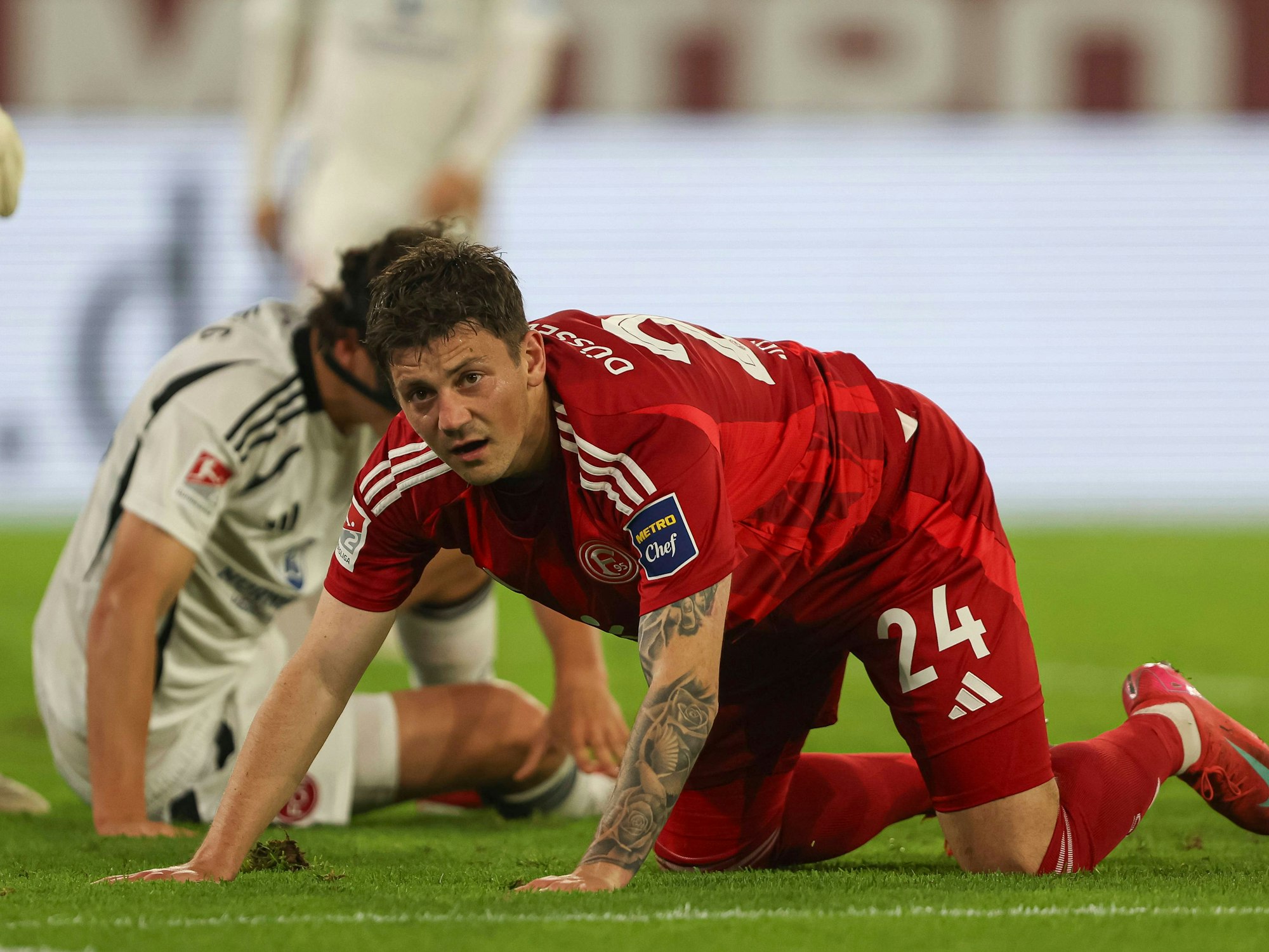 Dawid Kownacki kniet auf dem Rasen und stützt sich mit den Händen ab.