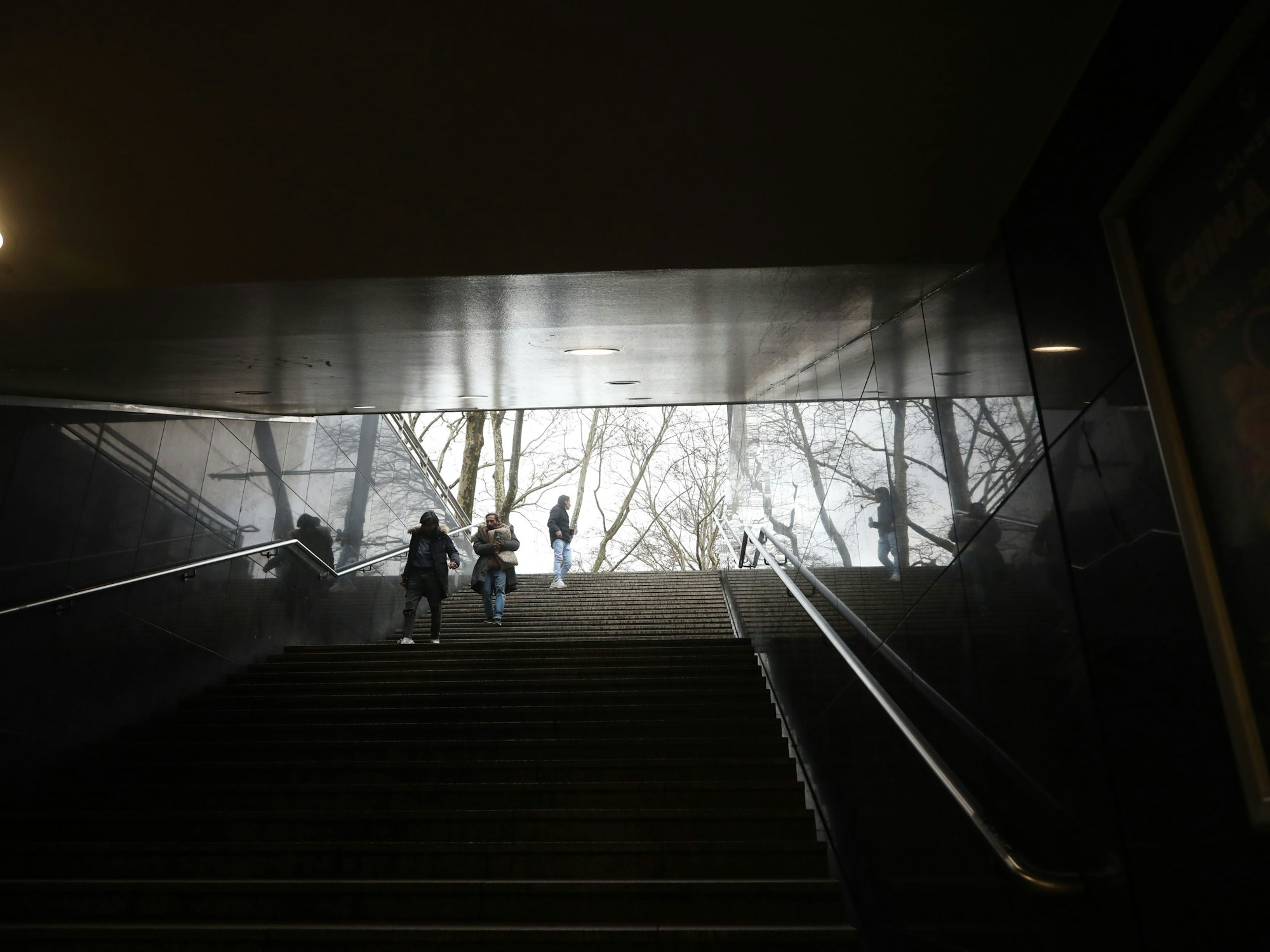 Eine Treppe führt aus dem Dunkel nach draußen.