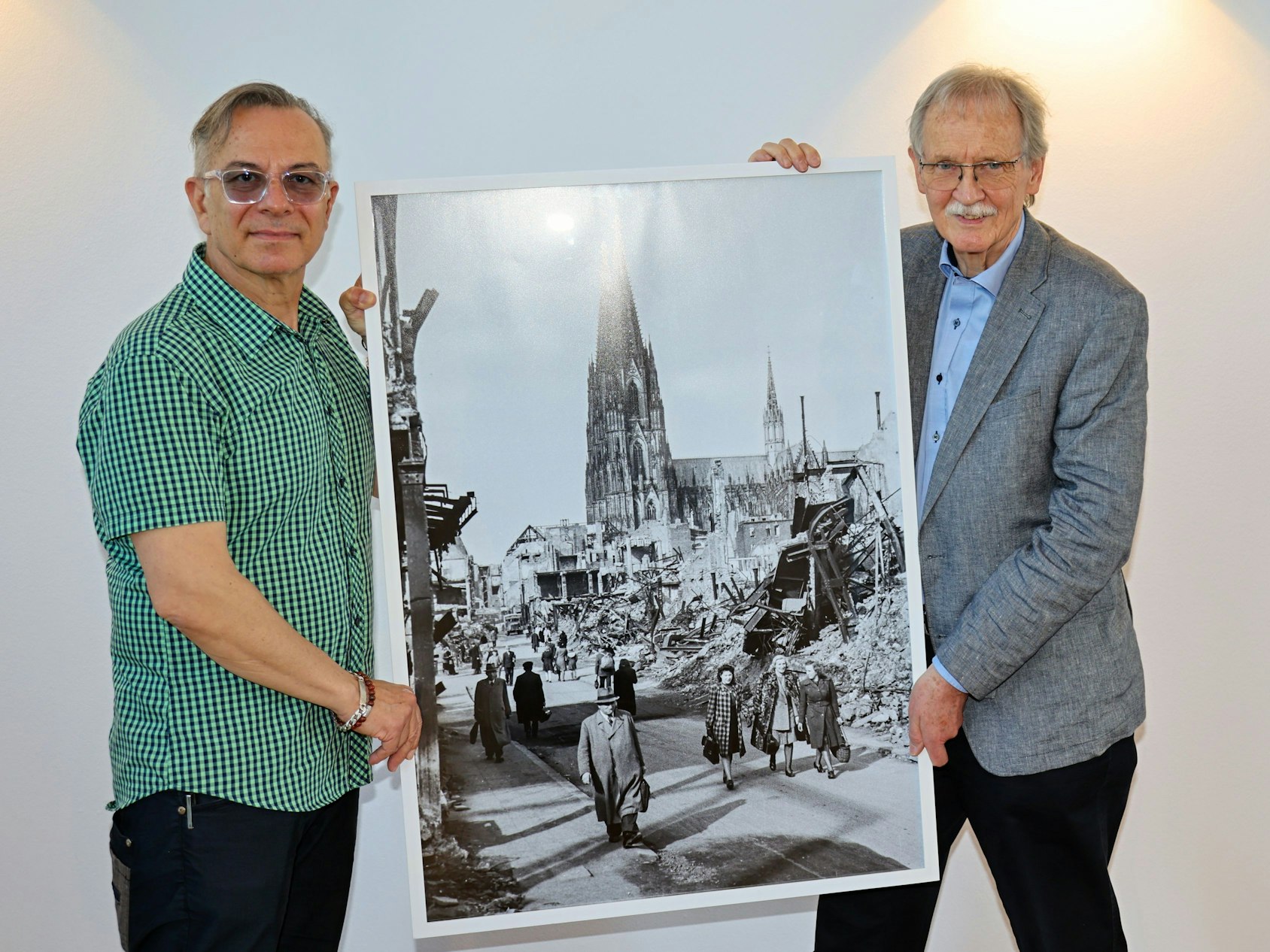 Ozan Akhan (l.) und Wolfgang Oelsner zeigen ein Foto.