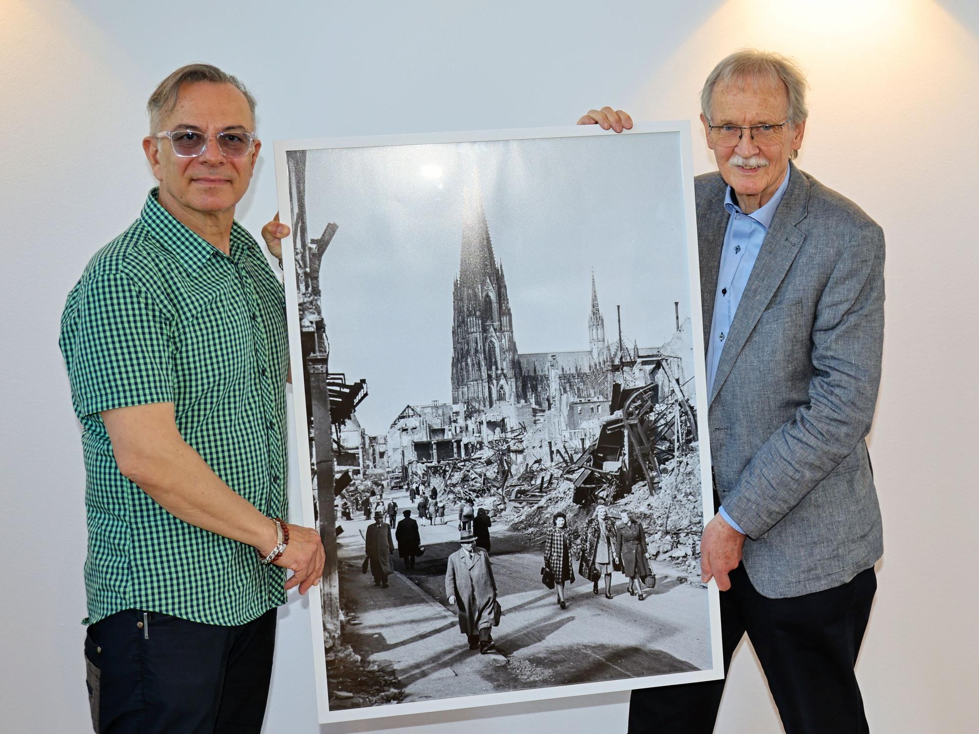Ozan Akhan (l.) und Wolfgang Oelsner zeigen ein Foto.