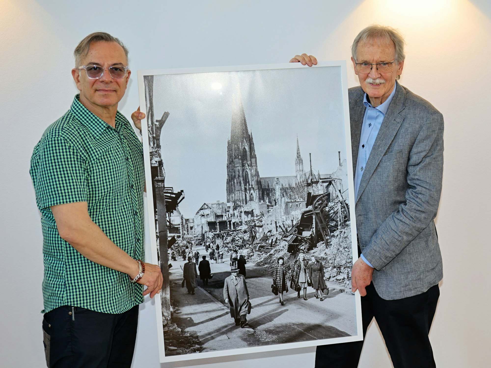 Ozan Akhan (l.) und Wolfgang Oelsner zeigen ein Foto.