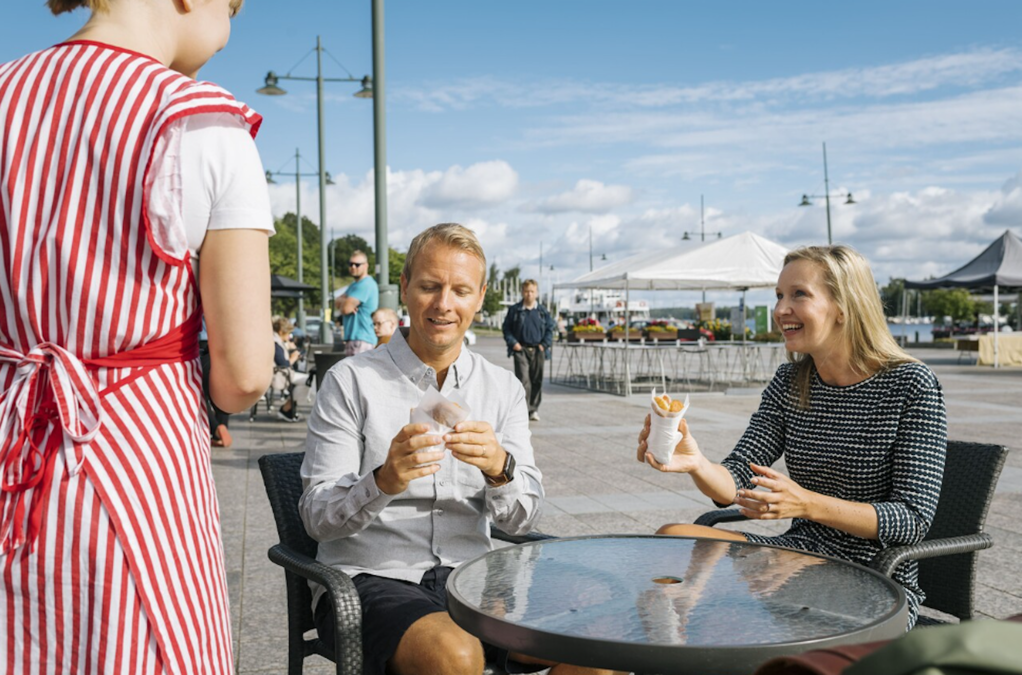 Bild vom Hafen in Lappeenranta. Zu sehen ist ein Mann und eine Frau, die an einem Tisch sitzen und bedient werden.