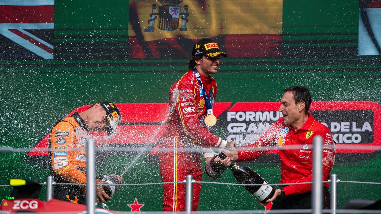 Carlos Sainz jubelt auf dem Podium und spritzt Champagner.
