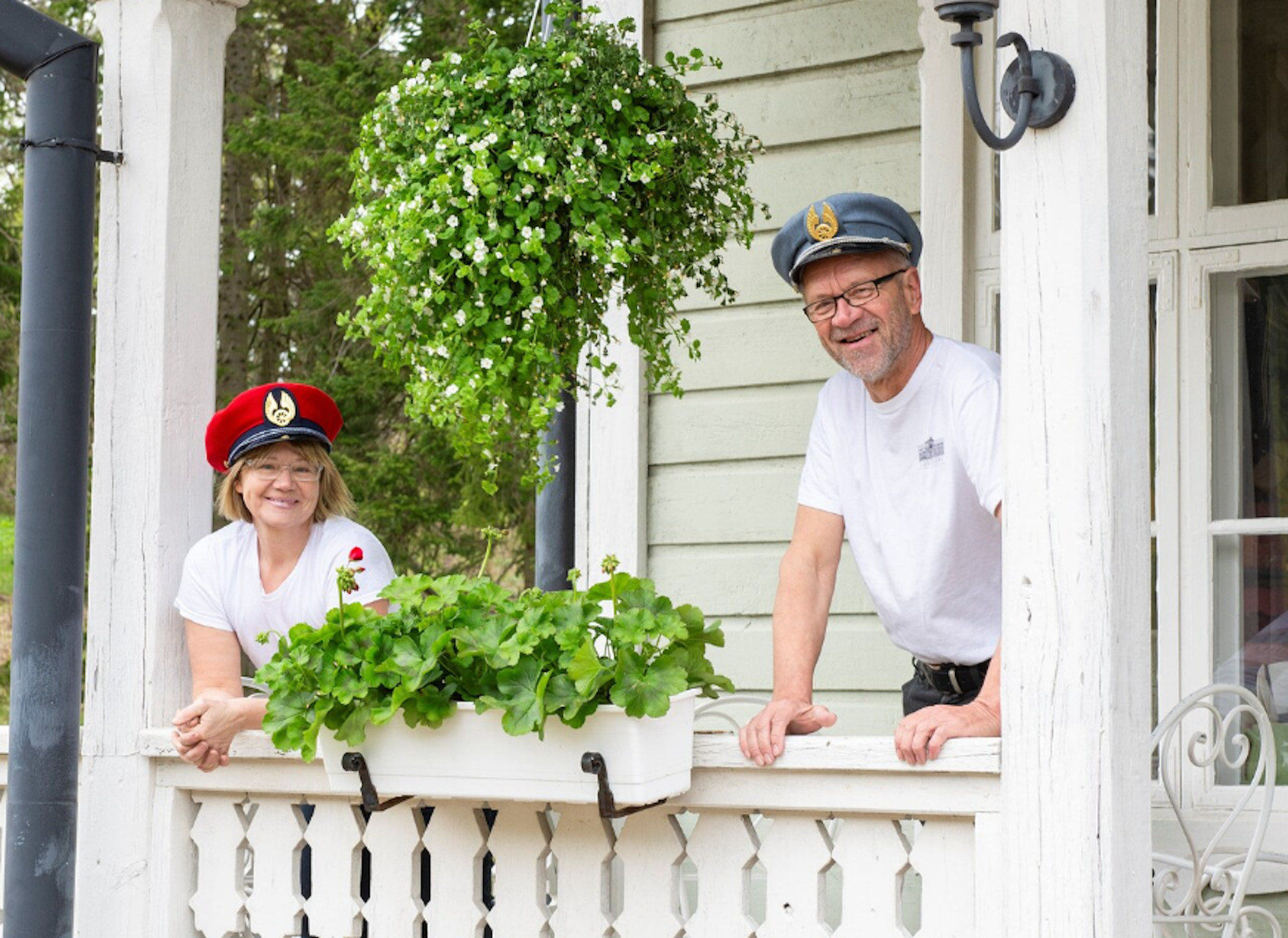 Ein Mann und eine Frau stehen auf einem Balkon mit Pflanzen und lächeln freundlich in die Kamera.
