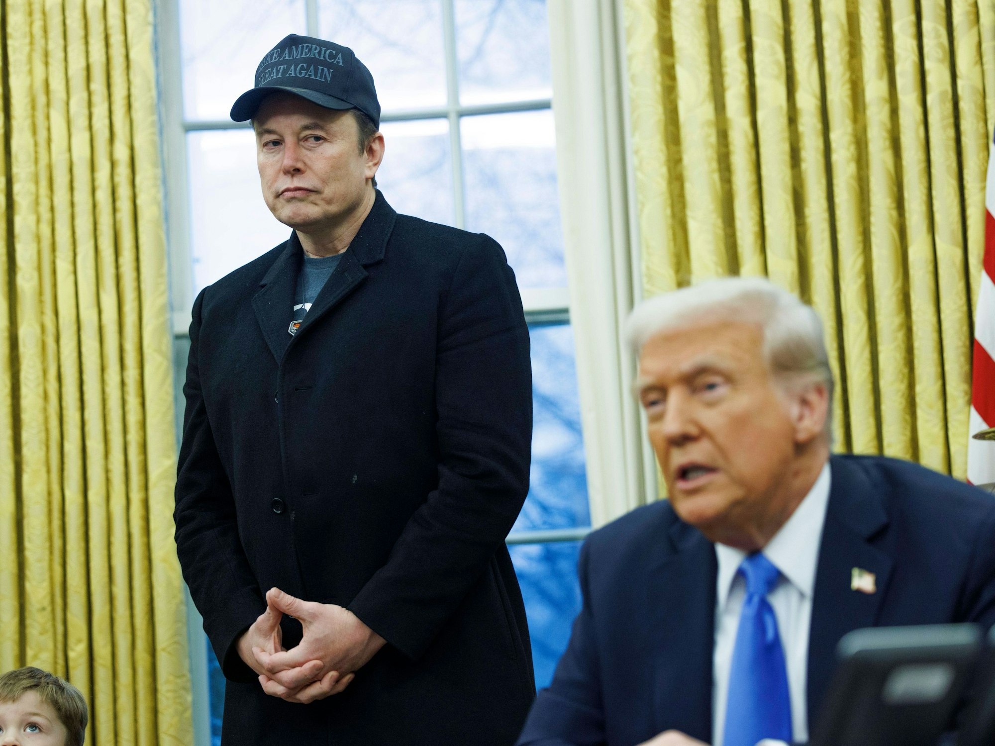 Elon Musk steht neben Donald Trump.