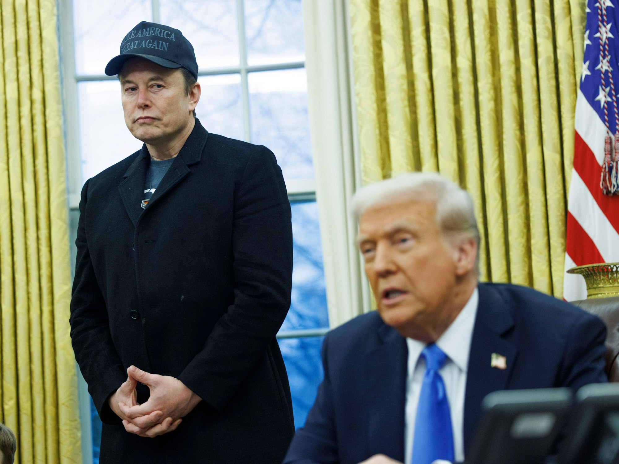 Elon Musk blickt während einer Ansprache auf Donald Trump