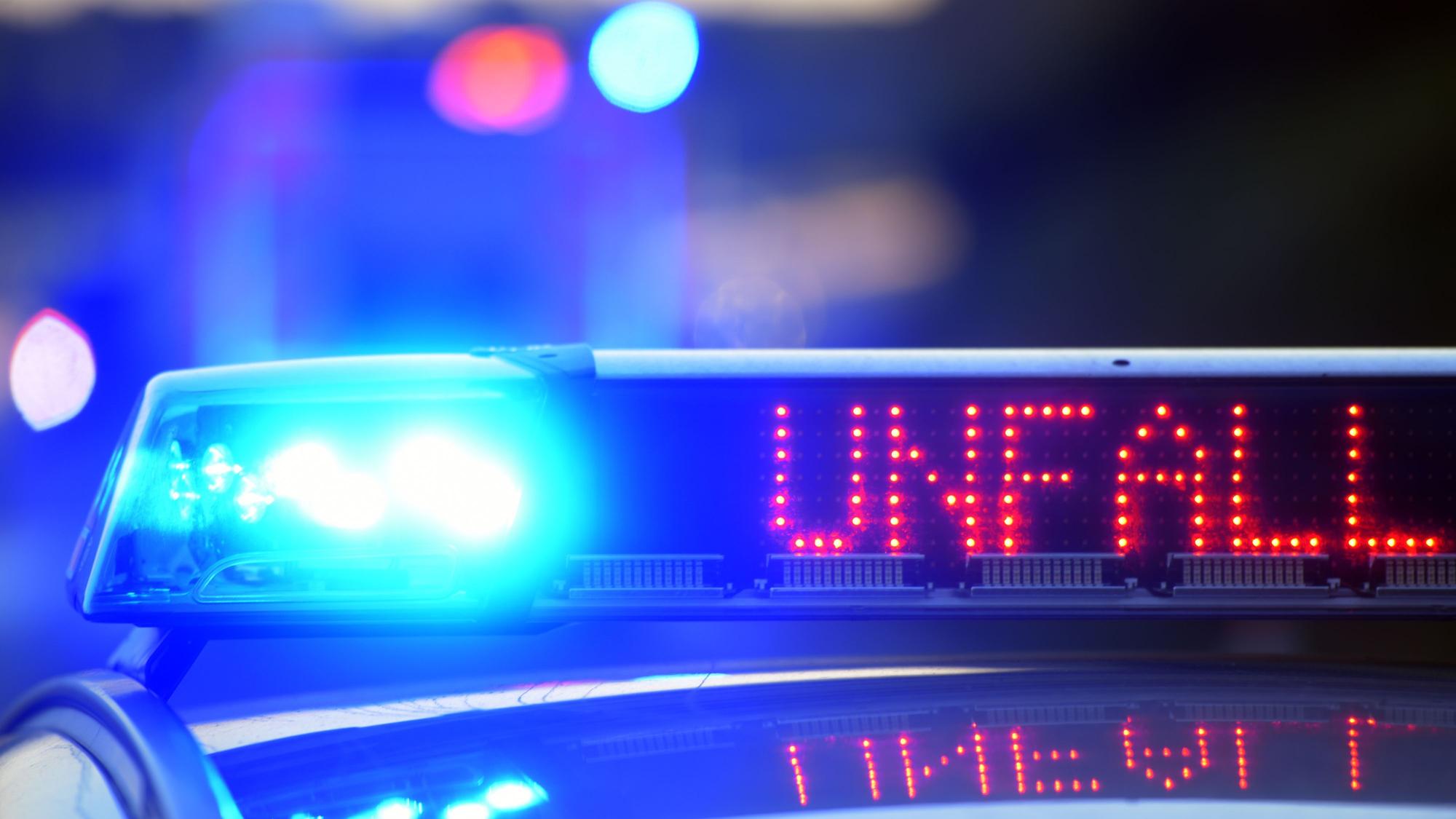 Auf einem Polizeifahrzeug warnt eine Leuchtschrift vor einer Unfallstelle.