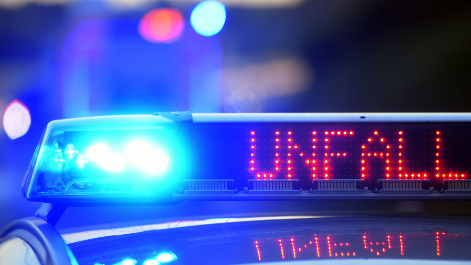 Auf einem Polizeifahrzeug warnt eine Leuchtschrift vor einer Unfallstelle.