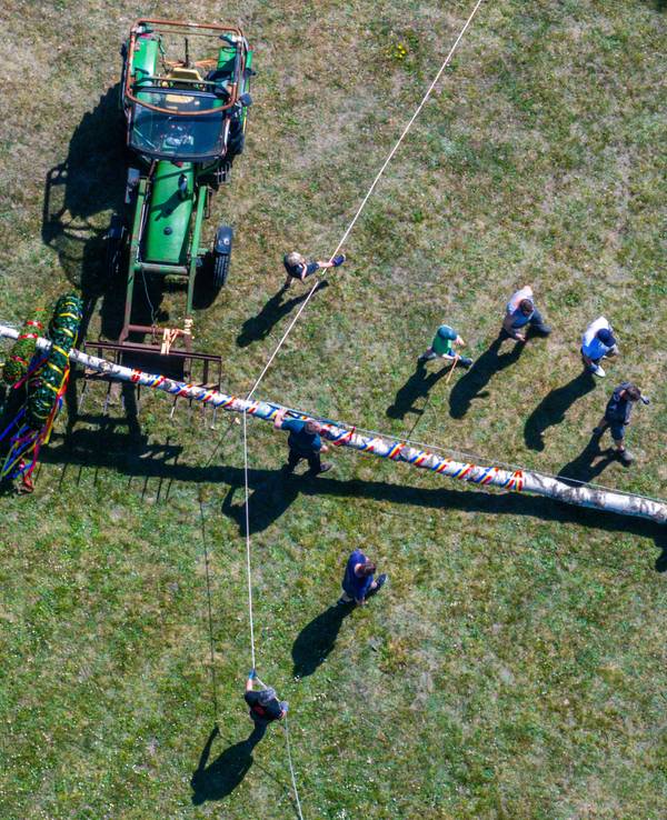 Mitglieder der Freiwilligen Feuerwehr und der Traktortruppe Pokrent (Mecklenburg-Vorpommern stellen am Dorfteich den traditionellen Maibaum auf.