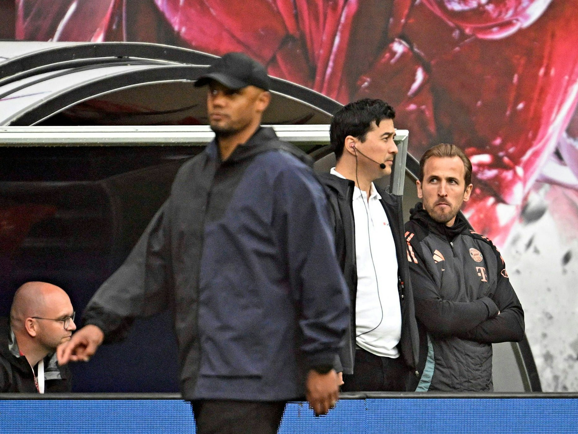 Harry Kane steht in Trainingsjacke im Innenraum.