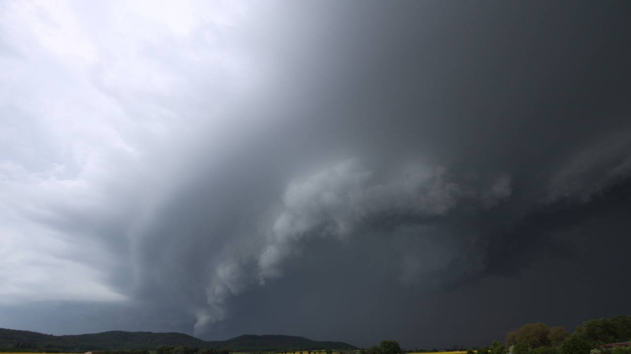 Dunkle Gewitterwolken haben sich hinter einem Rapsfeld in Bamberg gebildet.