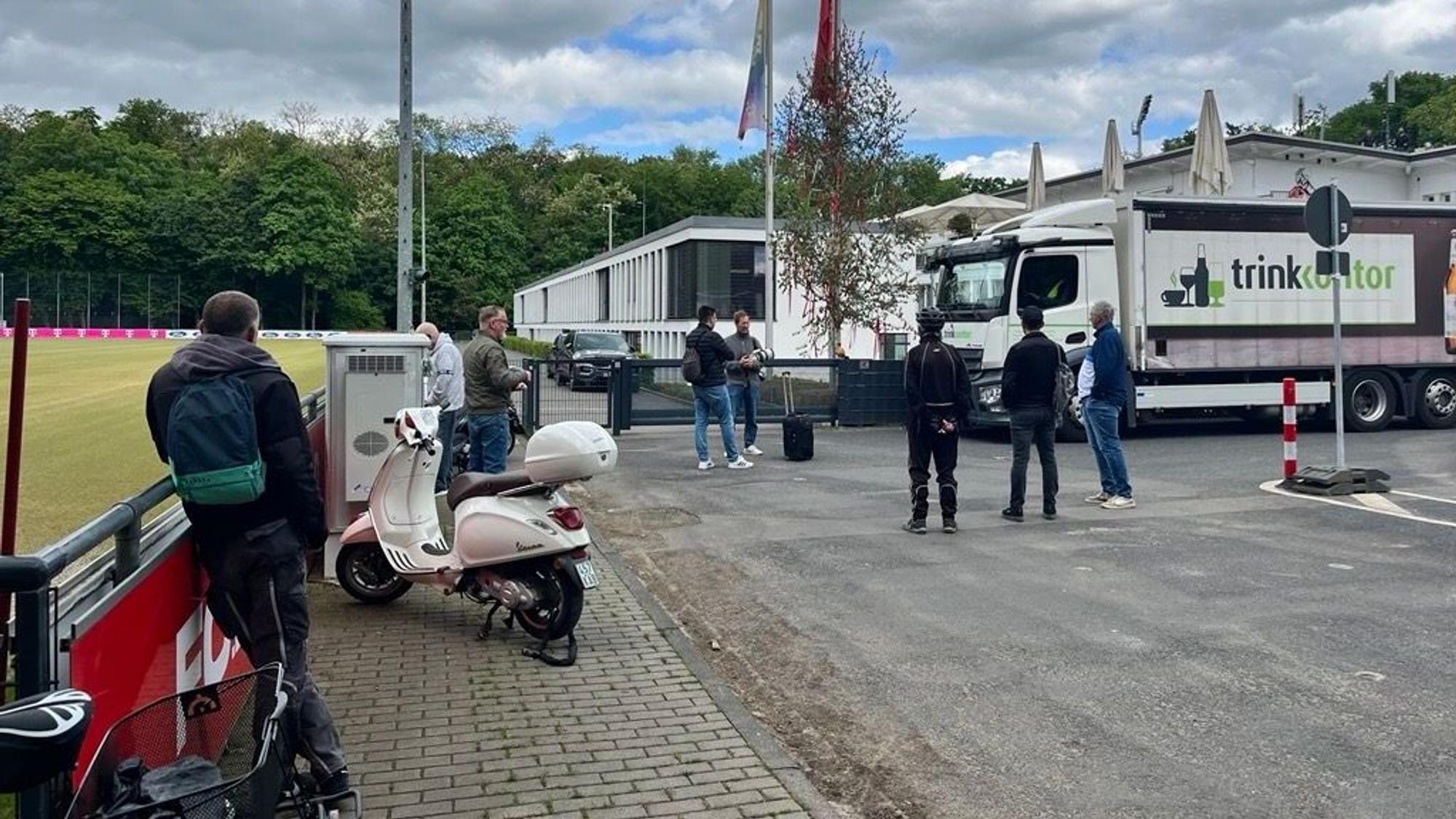 Einige Personen stehen am Geißbockheim.
