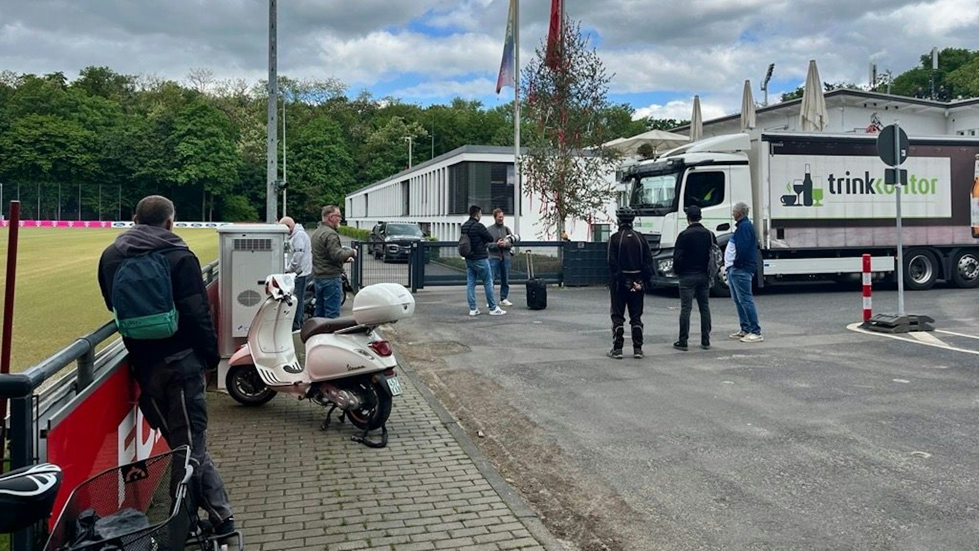 Einige Personen stehen am Geißbockheim.
