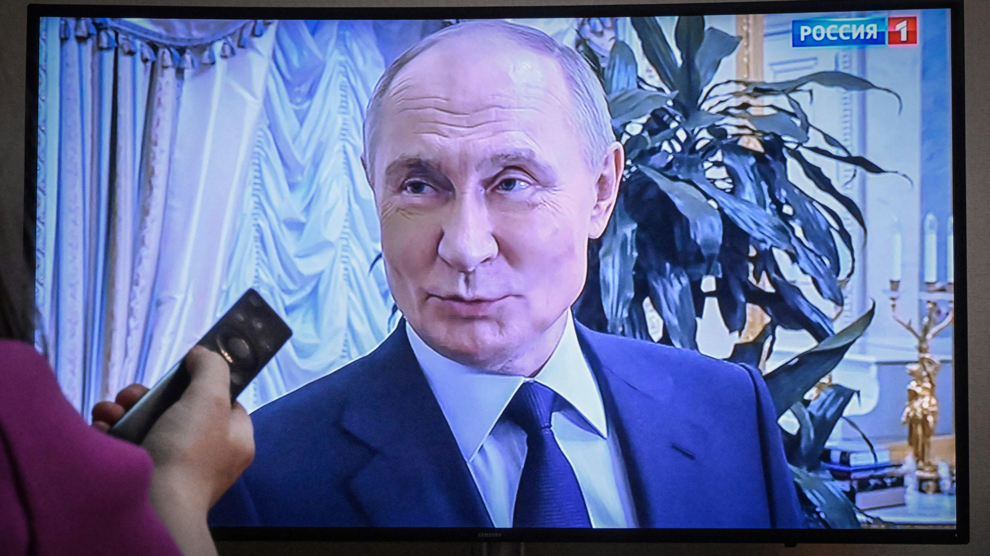 A woman watches a documentary on Russian President Vladimir Putin released on Russian state TV in Moscow on May 4, 2025. (Photo by Alexander NEMENOV / AFP)