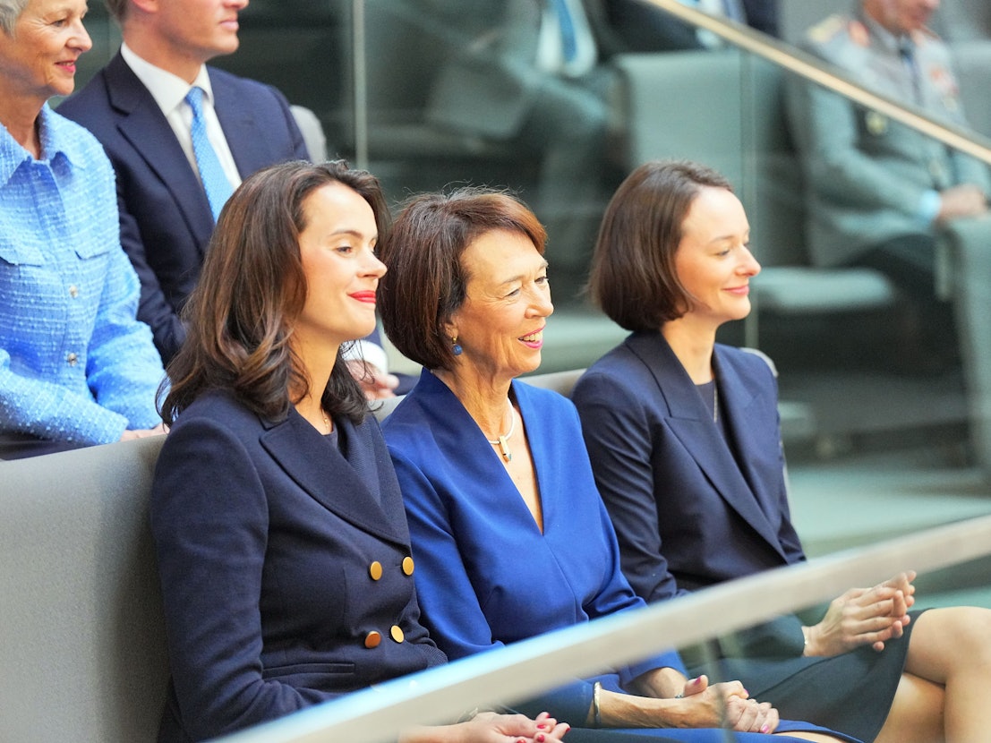 Charlotte Merz (M), Ehefrau des designierten Bundeskanzlers Merz, und ihre Töchter Carola Clüsener (l) und Constanze Merz sitzen vor der Kanzlerwahl im Bundestag auf der Tribüne.