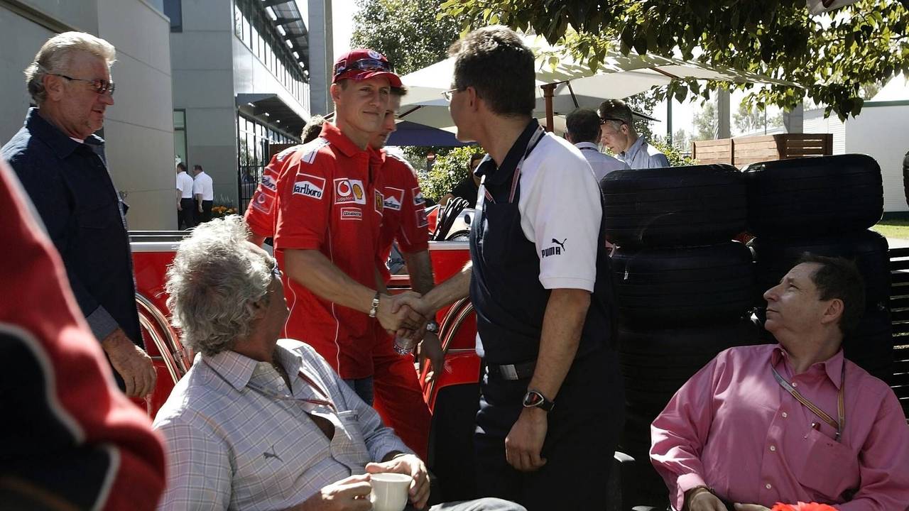 Flavio Briatore und Jean Todt schauen zu, als Schumi Dr. Mario Theißen die Hand schüttelt.