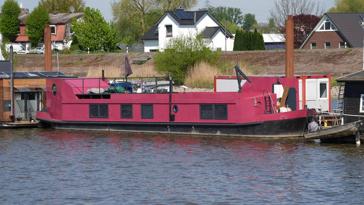 Das pinkfarbene Hausboot, auf dem Alexandra Fröhlich tot aufgefunden worden war, liegt an einem Steg im Holzhafen im Stadtteil Moorfleet.