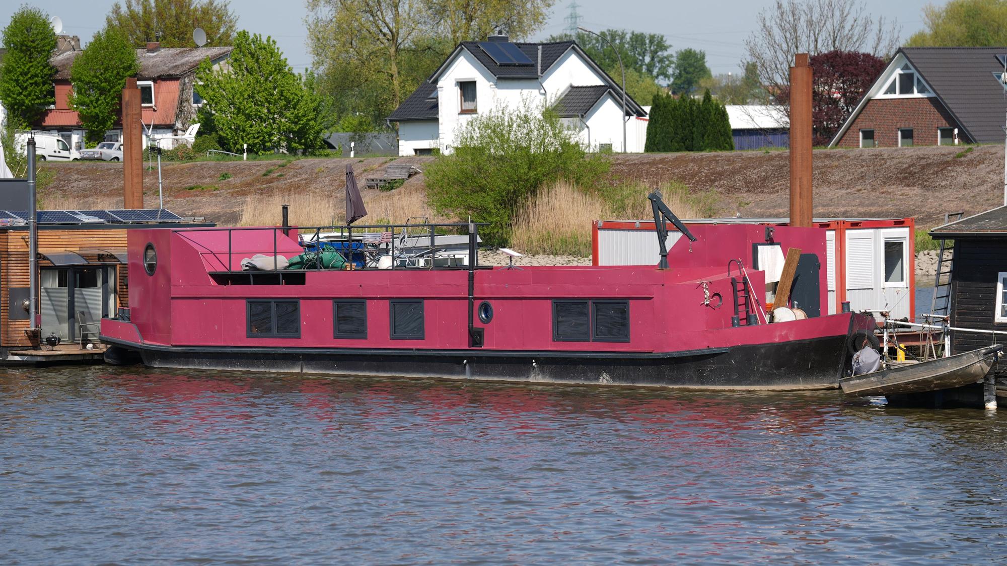 Das pinkfarbene Hausboot, auf dem Alexandra Fröhlich tot aufgefunden worden war, liegt an einem Steg im Holzhafen im Stadtteil Moorfleet.