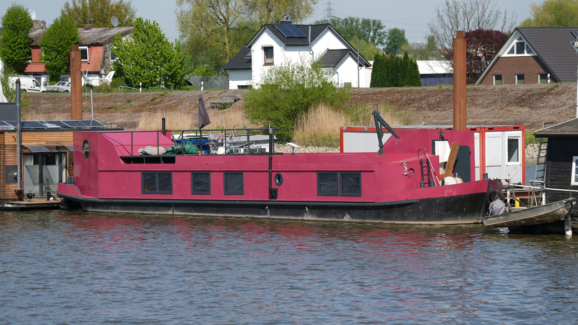 Das pinkfarbene Hausboot, auf dem Alexandra Fröhlich tot aufgefunden worden war, liegt an einem Steg im Holzhafen im Stadtteil Moorfleet.