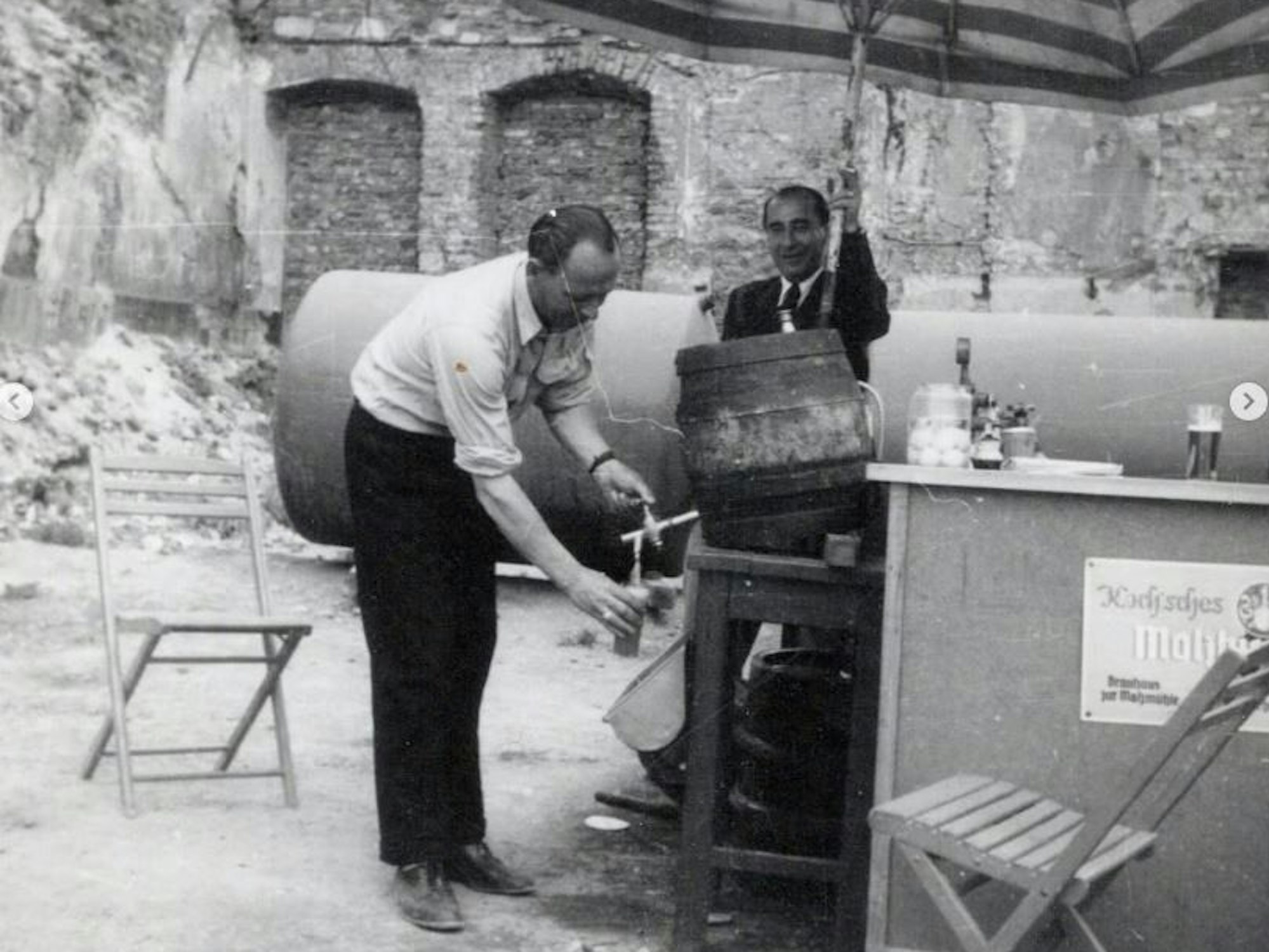 Ein Schwarz-Weiß-Bild zeigt einen Mann beim Kölschzapfen.