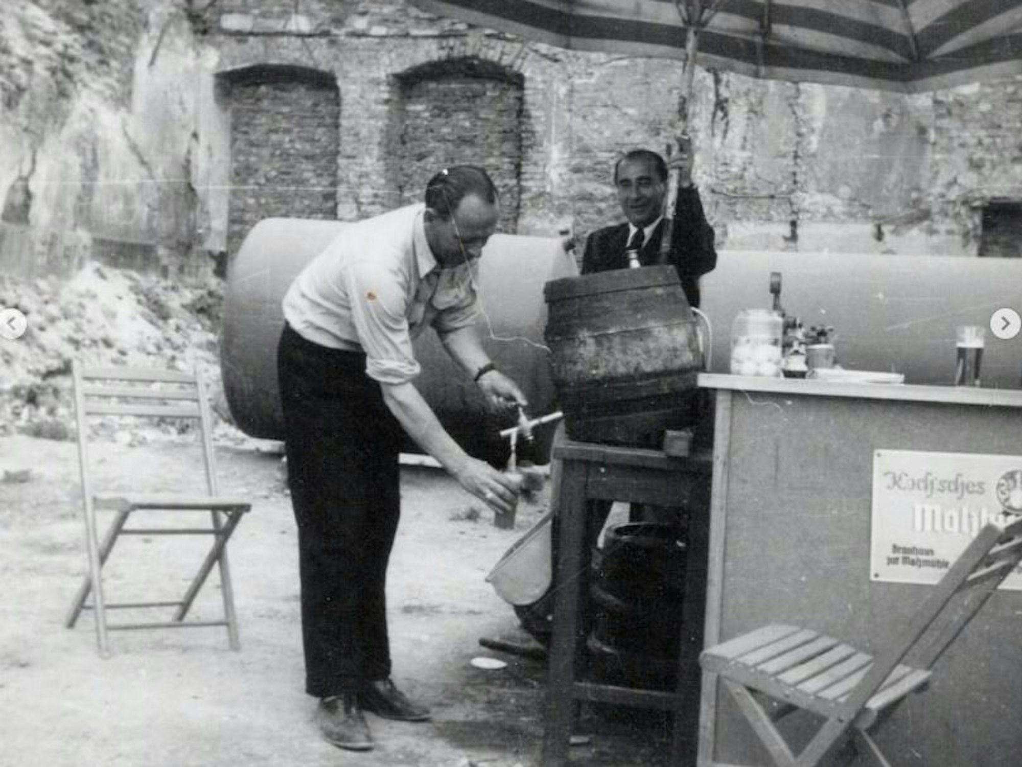 Ein Schwarz-Weiß-Bild zeigt einen Mann beim Kölschzapfen.