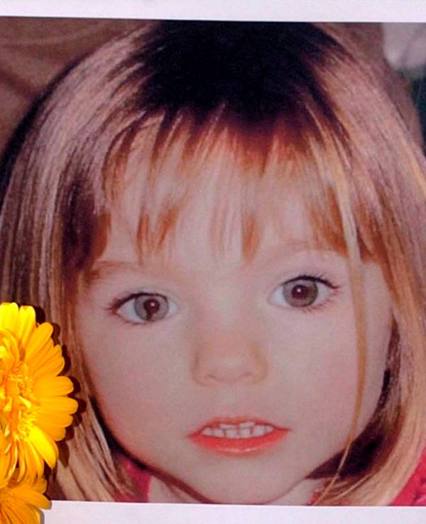 Blumen stehen vor einem Bild, das die verschwundene Madeleine McCann (Maddie) auf einem Foto zeigt, das ihre Eltern im Zusammenhang mit dem Verschwinden des Kindes am 3. Mai 2007 veröffentlich haben.