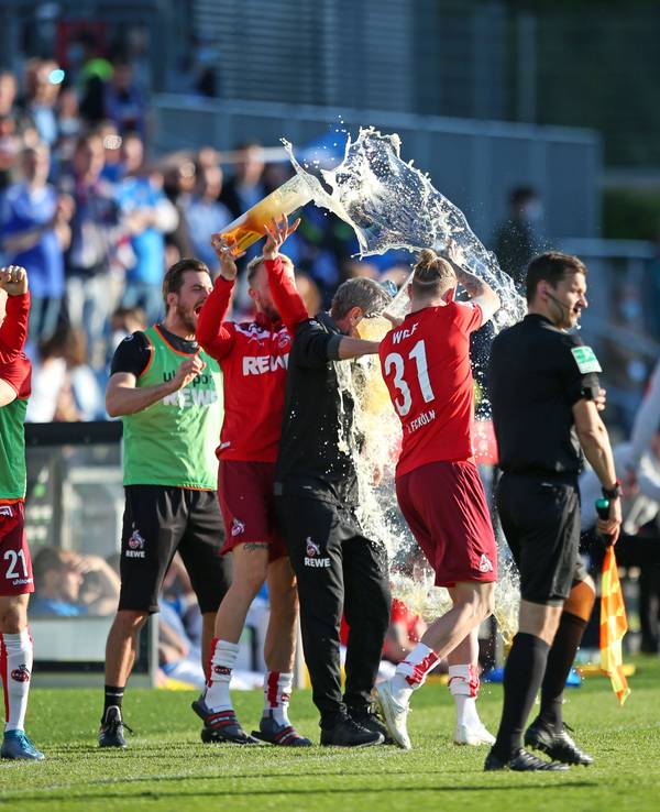 Friedhelm Funkel wird mit Bier übergossen beim Klassenerhalt mit dem 1. FC Köln 2021.